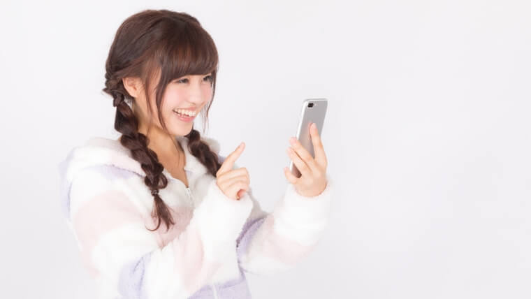 スマホ画面を見て喜ぶ女の子